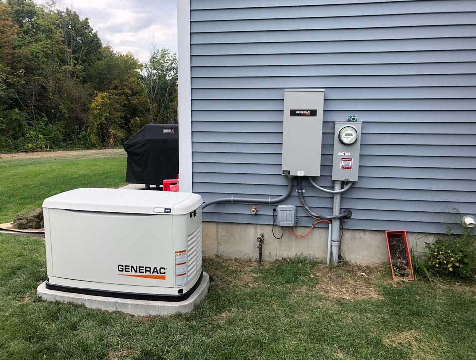 A generator and an electrical panel on the side of a house.